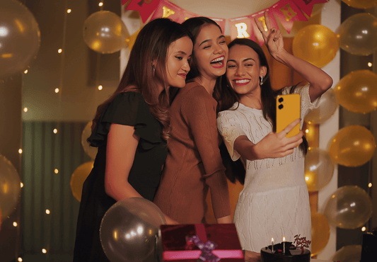 Three female teens happily posing for a selfie in a trendy birthday party.