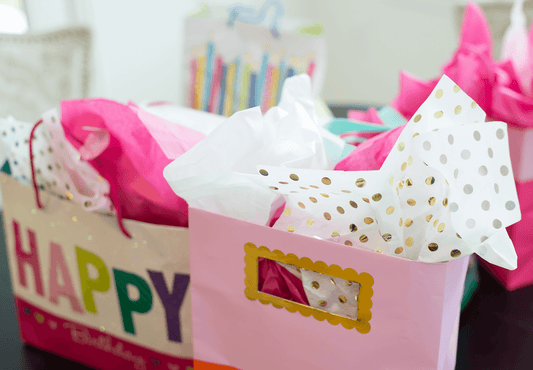 Colorful wrapped birthday gifts displayed on a table.