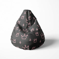Front image of a beanbag with pink crowns and stars on a dark 